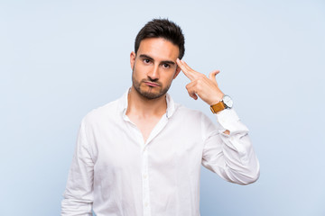 Handsome young man over isolated blue background with problems making suicide gesture