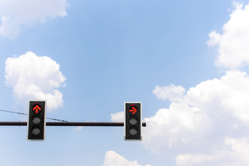 Red color traffic light whit a beautiful blue sky and cloudy background.