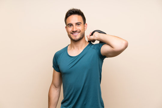 Handsome sport man over isolated background with kettlebell - Powered by Adobe