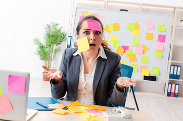 Young female employee in conflicting priorities concept 