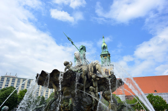 Berlin, Germany famous Neptune fountain with the Marien Church in the city center east