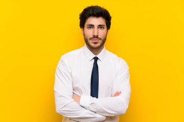 Businessman on isolated yellow background keeping arms crossed