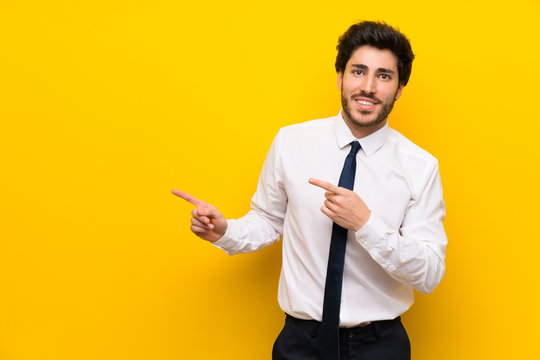 Businessman on isolated yellow background pointing finger to the side