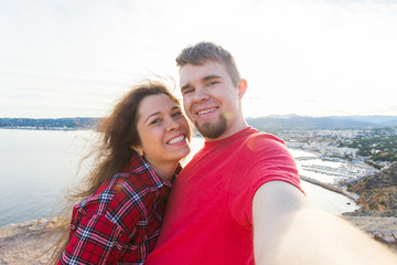 Travel, vacation and holiday concept - Beautiful couple having fun, taking selfie, crazy emotional faces and laughing.