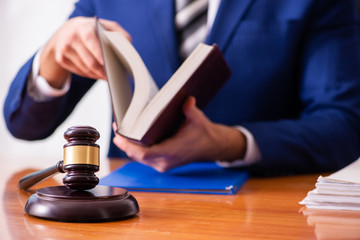 Young male judge sitting in courtroom 