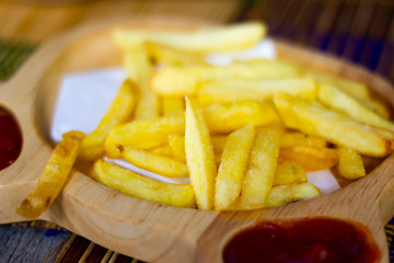 French fries and  ketchup on wood table,  junk food and unhealthy food