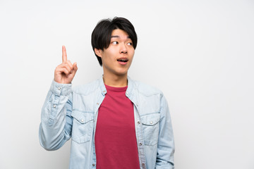 Asian man on isolated white background intending to realizes the solution while lifting a finger up