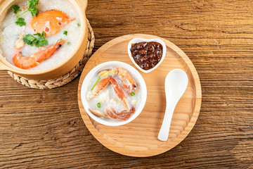 Nutritious delicious crab seafood porridge in a bowl on wooden table