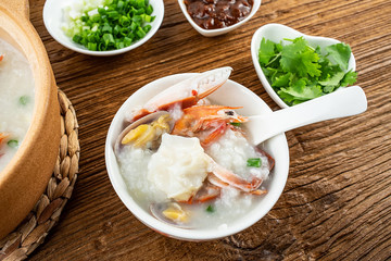 Nutritious delicious crab seafood porridge in a bowl on wooden table