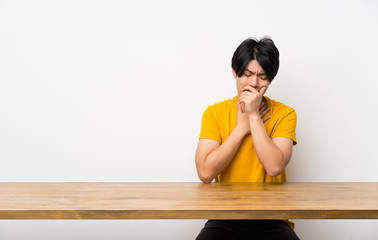 Asian man with yellow shirt is suffering with cough and feeling bad