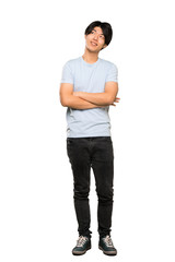 A full-length shot of a Asian man with blue shirt looking up while smiling over isolated white background