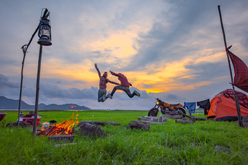 Fototapeta na wymiar couple lover enjoy camping in jumping freedom, countryside traveling of the couple lover, campfire enjoying