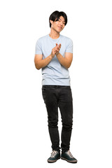 A full-length shot of a Asian man with blue shirt applauding after presentation in a conference over isolated white background