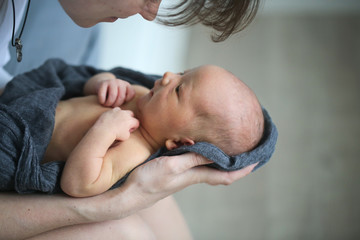 Newborn baby in mom's hands,top view. Casual style