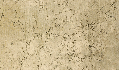 Obraz premium Damaged wall of the old house with peeling yellow plaster