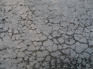 The old crumbling asphalt driveway with a textured surface