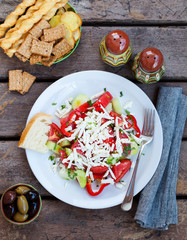 Vegetable Bulgarian shopska salad. Wooden background. Top view.