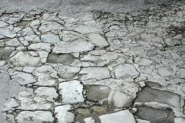 Asphalt road with a broken surface and cracking
