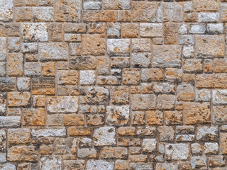 Pattern gray color of old style design decorative uneven cracked real stone wall surface with cement. Old beige stone wall background texture. Part of a stone wall, for background or texture.