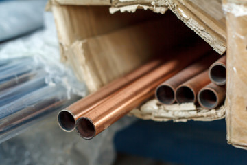 Closeup of a stack of copper pipes for water and heating systems, soft focus