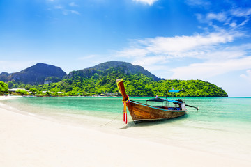 Thai traditional wooden longtail boat and beautiful sand beach. - obrazy, fototapety, plakaty