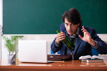 Male teacher drinking in the classroom 