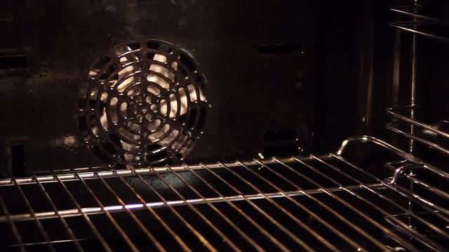 opening the door of empty preheated kitchen stove