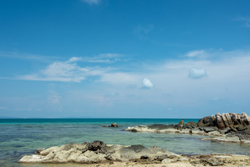 The background of a large rocky island in the blue sea and a blue sky
