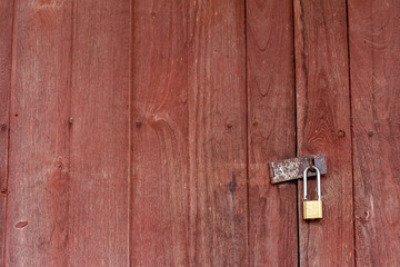The background is a wooden door, the old house has an iron hinge and a key to lock the door.