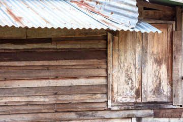 The wooden windows of the old houses with zinc roofs that began to rust