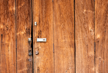 The background is a wooden door, the old house has an iron hinge and a key to lock the door.