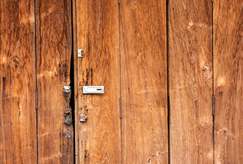 The background is a wooden door, the old house has an iron hinge and a key to lock the door.