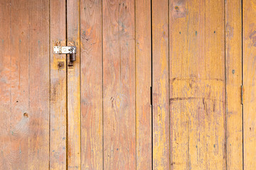 The background is a wooden door, the old house has an iron hinge and a key to lock the door.