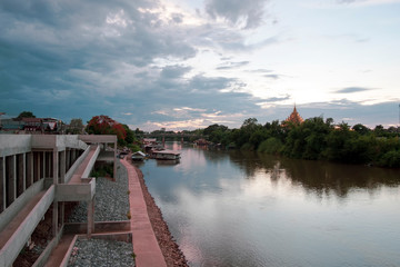 Fototapeta premium River view in urban city with house boat, bridge and temple before the storm coming.