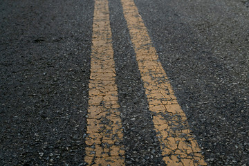Background of two yellow line crack on asphalt road.
