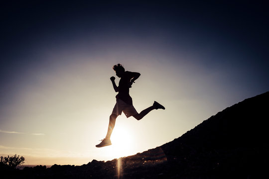 teenager running in mountains at the sunset - runner life and sportive concept - outdoor lifestyle