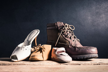 still life photography : family concept, father mother son and daughter old shoes on old wood with...