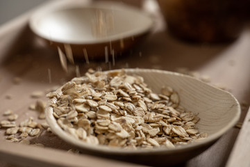 Explosion of oat flakes in a bamboo bowl