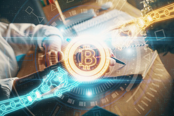 Cryptocurrency hologram, bitcoin, ico theme over hands taking notes background. Concept of blockchain. Multi exposure