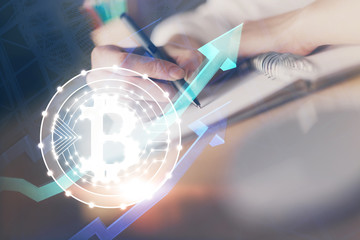 Cryptocurrency hologram, bitcoin, ico theme over hands taking notes background. Concept of blockchain. Multi exposure