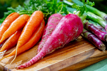 Bunches of fresh red long radish, carrots and purple onion, new harvest of healthy vegetables