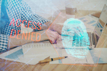 Fingerprint hologram with businessman working on computer on background. Security concept. Double exposure.