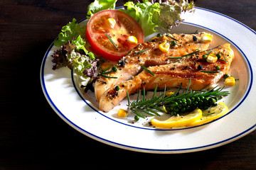 Grilling fresh salmon with salt and black pepper in the hot pan which has smoke