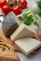 Italian cheeses, mature Tuscan Pecorino sheep cheese and Provolone dolce cow cheese served with olive bread and tomatoes