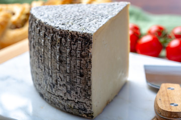 Italian cheese, piece of mature Tuscan Pecorino sheep cheese served with olive bread and tomatoes