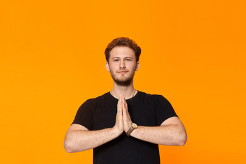 Studio shot of a bearded young man expressing emotion of appeal.