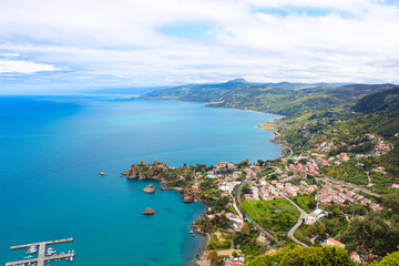 Beautiful countryside landscape around village Cefalu, Sicily, Italy located in a bay on the Tyrrhenian coast. Captured from above with the pier in the sea and green hills behind the bay