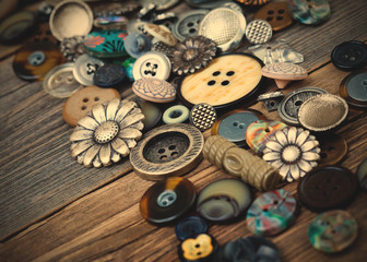 Vintage buttons in large numbers scattered on aged wooden boards