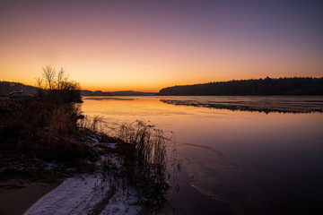 Obraz premium dramatic red sunset colors in the sky above trees and fields