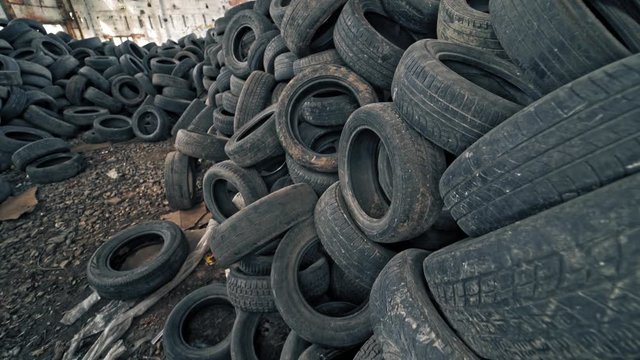 Lot of old tires from cars. Second hand tyres stacked up at old dump